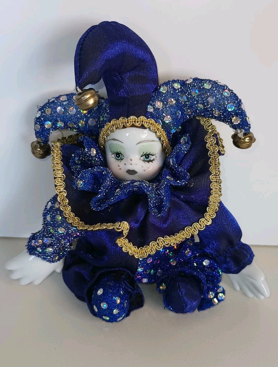 a porcelain faced softbody jester with large porcelain hands