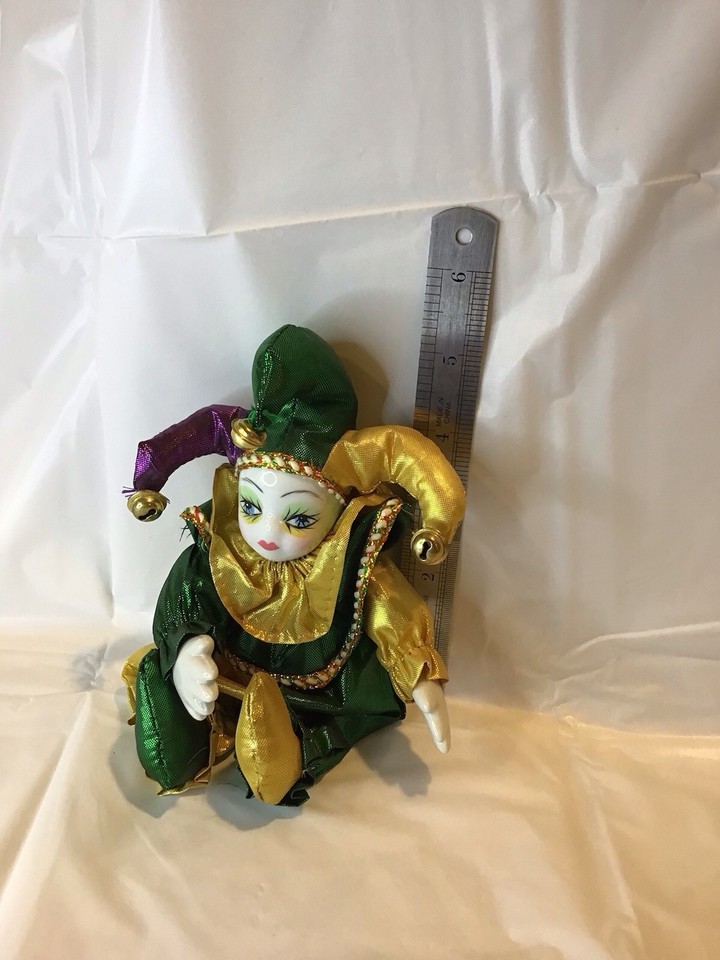 a small jester sits next to a ruler