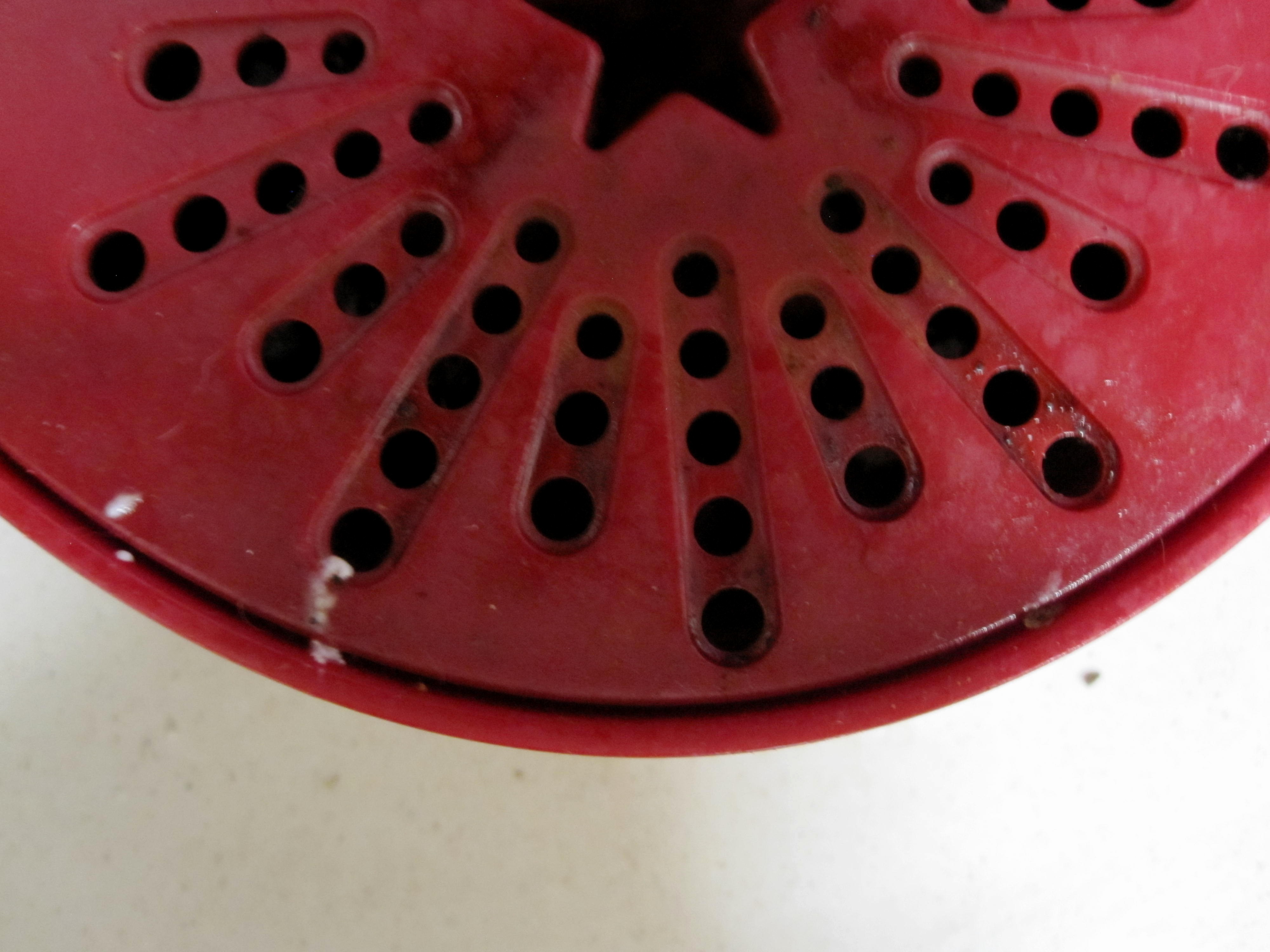 the pedestal of a keurig with a star shaped drainage hole
