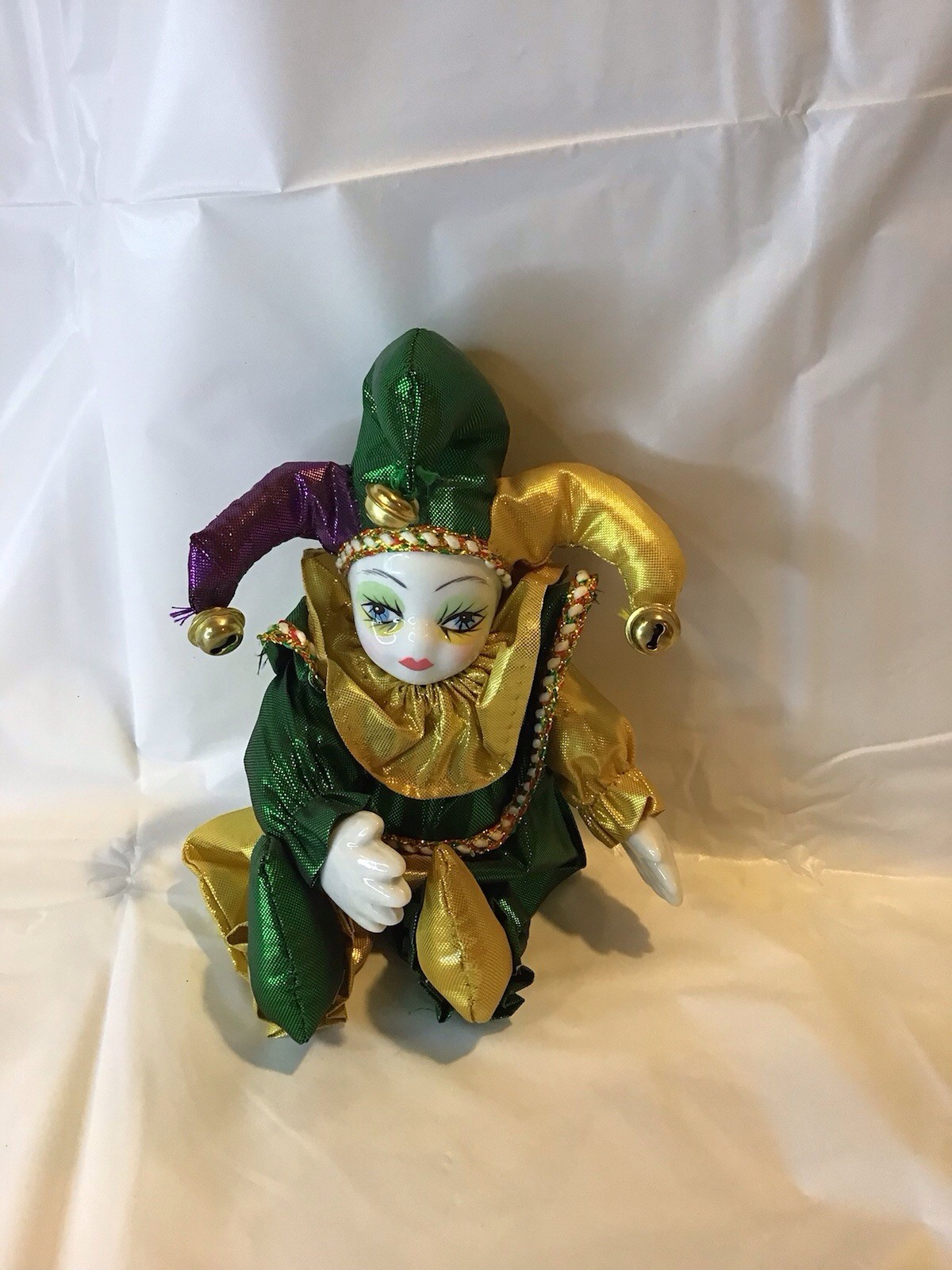 a small soft jester with a porcelain face, which bears a displeased expression