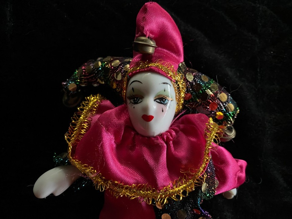 close up of a saucy looking porcelain faced clown