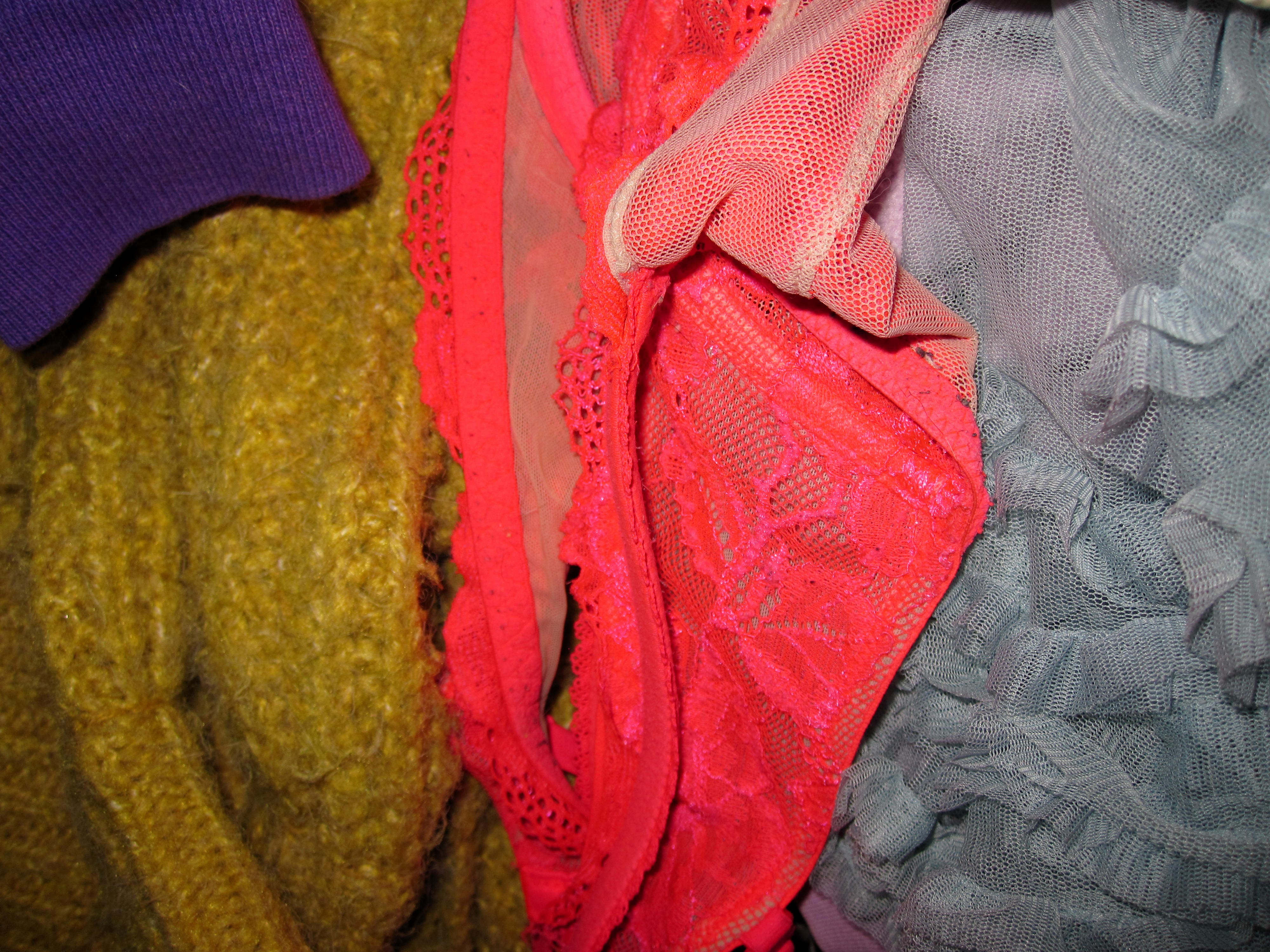 green, purple, and pink lace and knits layered on top of each other in a pile